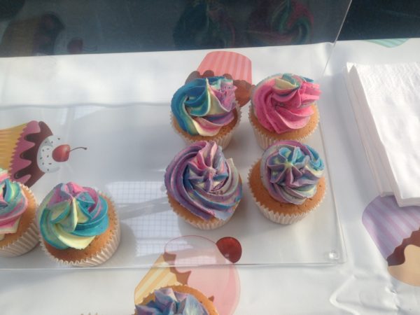 four rainbow cup cakes