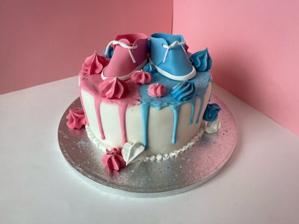 gender reveal cake with baby shoes