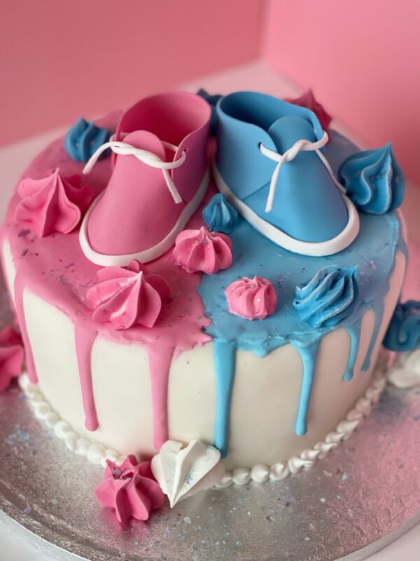 gender reveal cake with baby shoes
